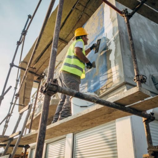 A construction worker builds the facade of a building
